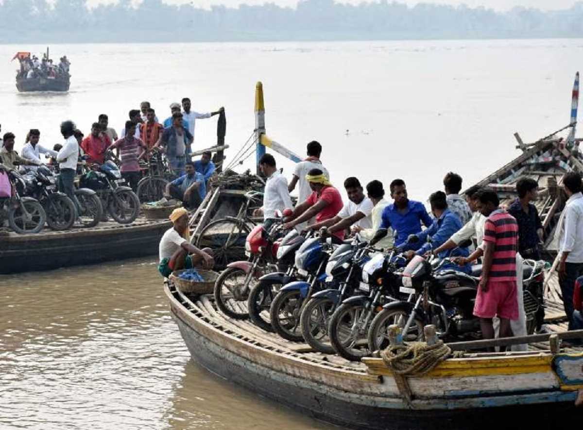 पटना में नाव पर वाहन के साथ सवार लोग, जान जोखिम में डालकर पार कर रहे गंगा नदी